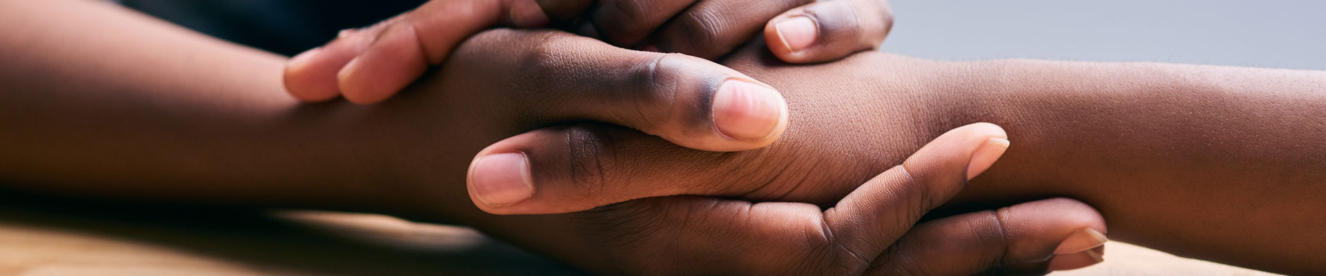 close-up shot of holding hands for comfort and emotional support
