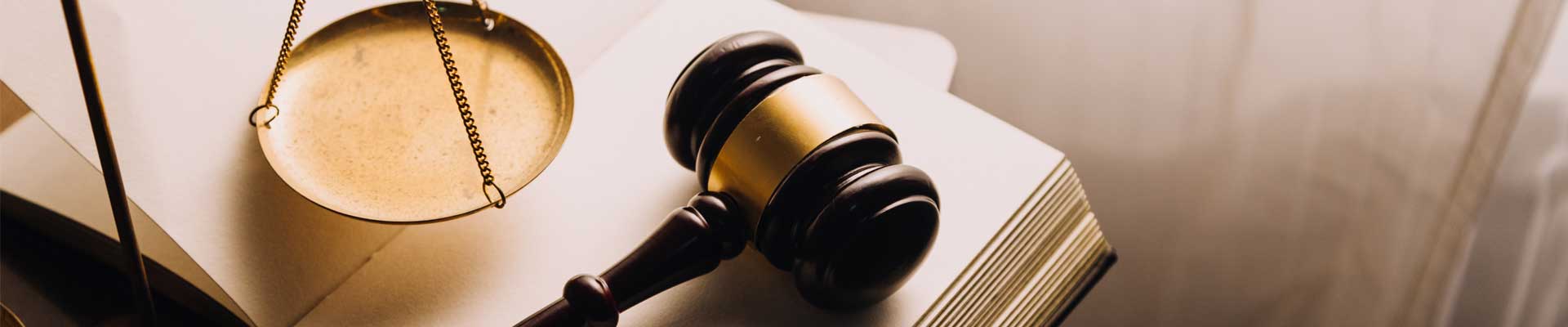 a Scale of Justice and a gavel on a book representing law