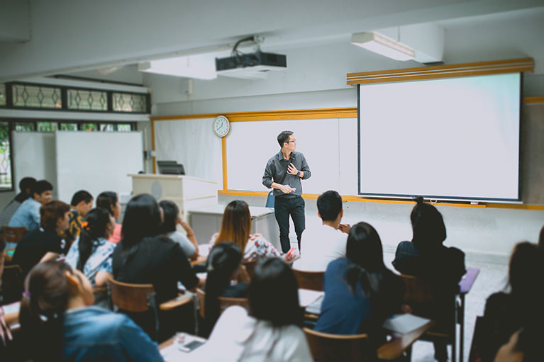 Teacher presenting to a full classroom