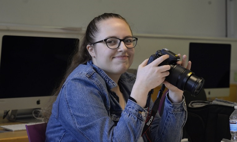 Portrait of Jana Buxbaumova holding a camera and smiling,
