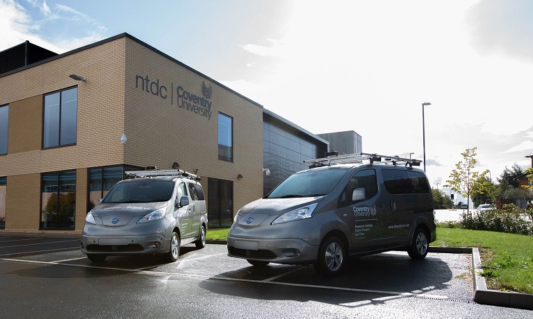 two university vehicles parked outside a university building