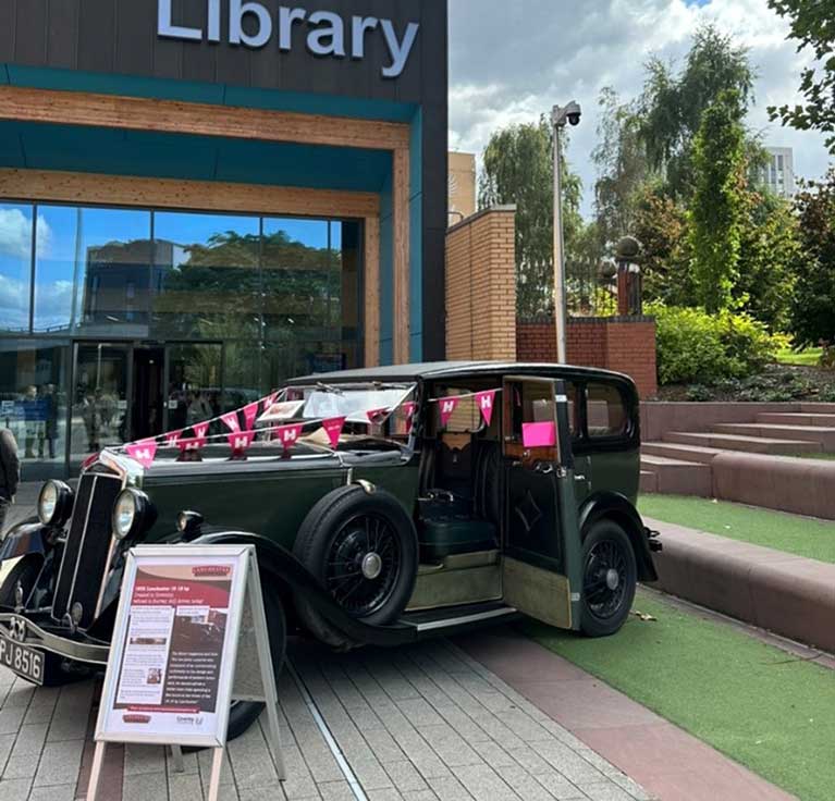 Coventry University's Library grand opening picture of an entrance and a decorated classic car in front