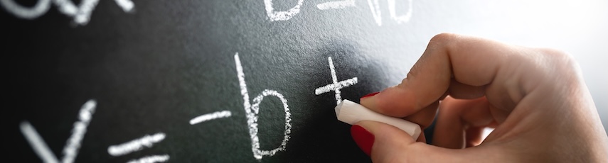 A blackboard with a hand writing mathematical equations on it with white chalk