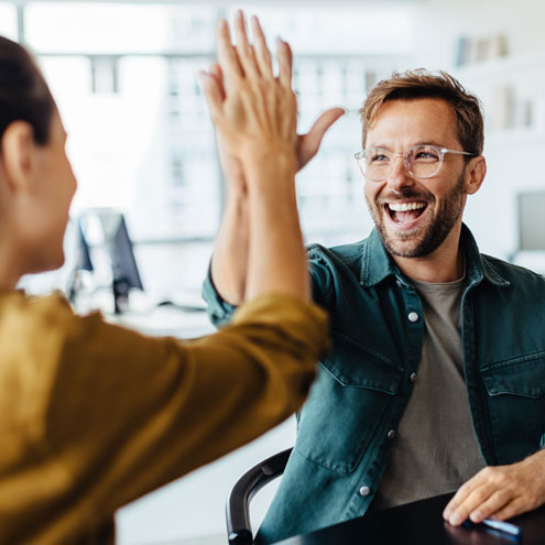 two colleagues high fiving each other following secured business funding application
