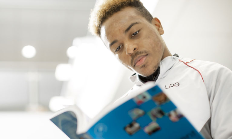 Male student holding a text book