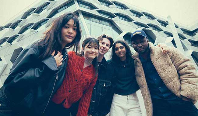 Five students looking down at the camera outside the Frank Whittle engineering building