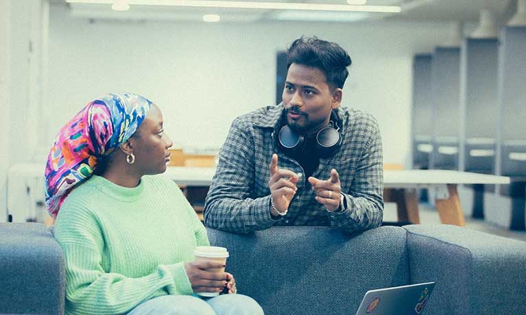 Two students chatting in a breakout area