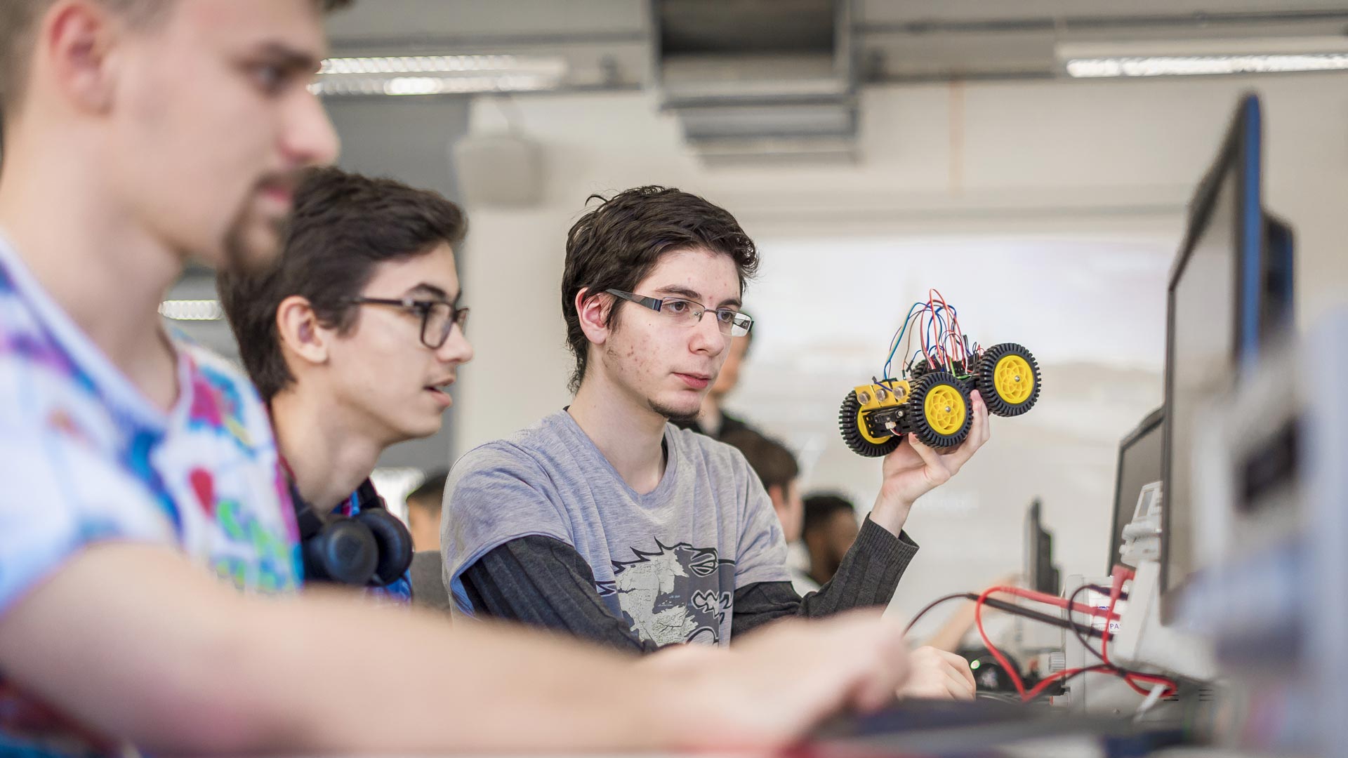 Group of students working on programming a car