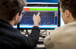 Two students looking at software on a computer screen the student on the left is pointing to the screen