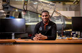 Student sat at a desk in front of engineering equipment