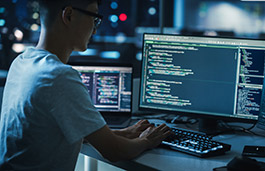 Man working on a computer that displays random code