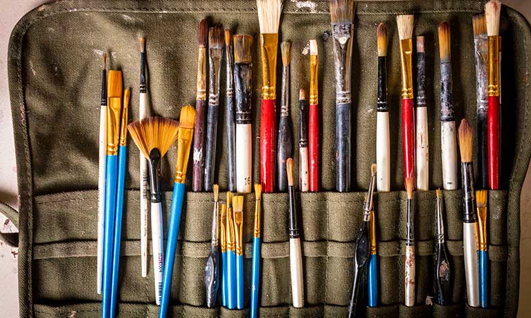 Various sized paint brushes in a paint brush holder