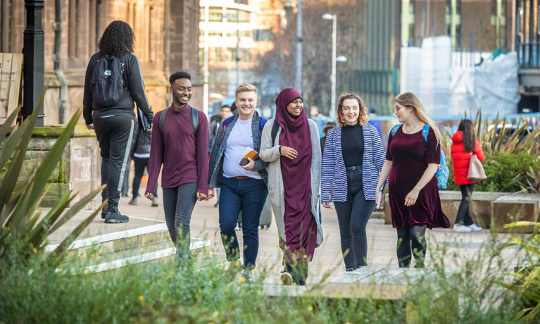 Group of students sat chatting in a learning pod at Coventry University