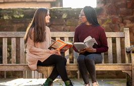 Two students sitting in the Coventry Cathedral ruins