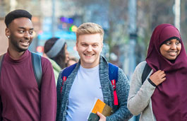 smiling students walking across campus