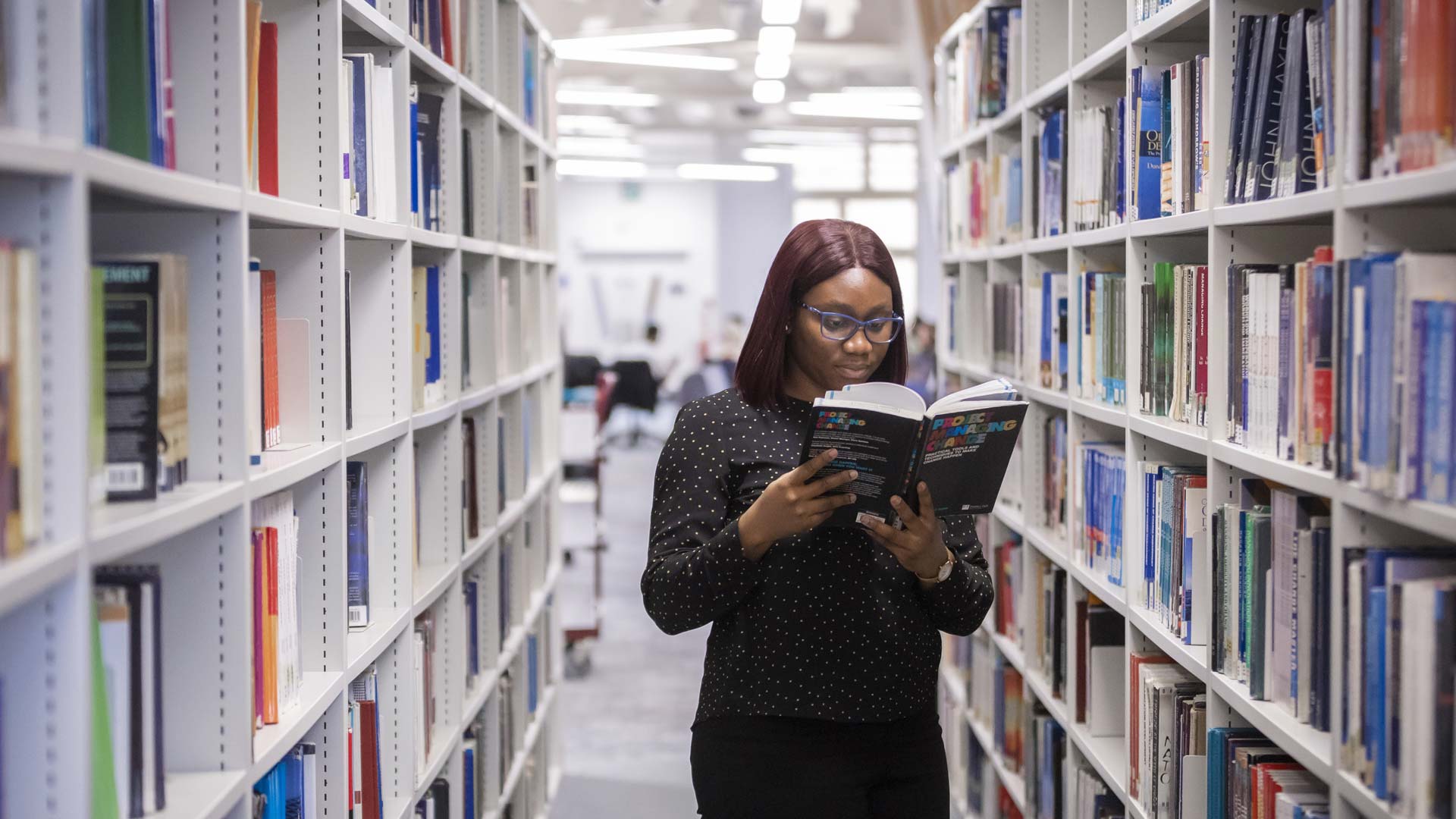 Student reading a book in the library