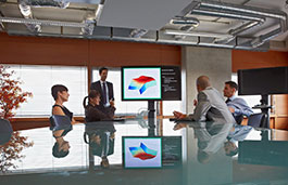 two females and three males sat around a table having a business meeting