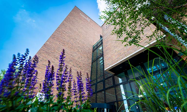 A view of the Alison Gingell building with flowers next to it.