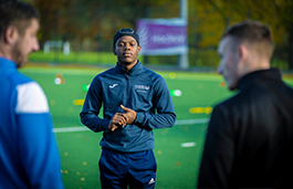 Students on a football pitch training 