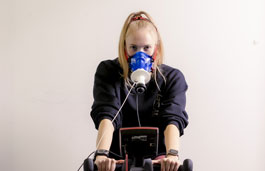 student using exercise bike and breathing measurement equipment