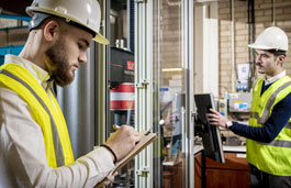 student in high vis with clipboard in engineering workshop