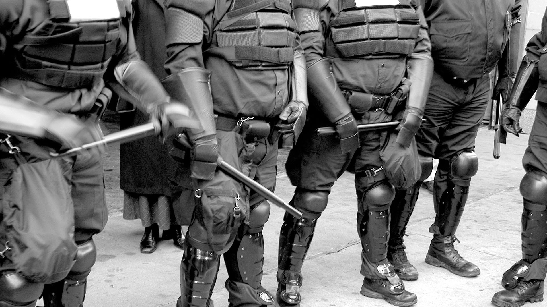 Black and white photo of police in riot gear