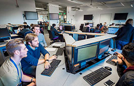 People using computers at several desks