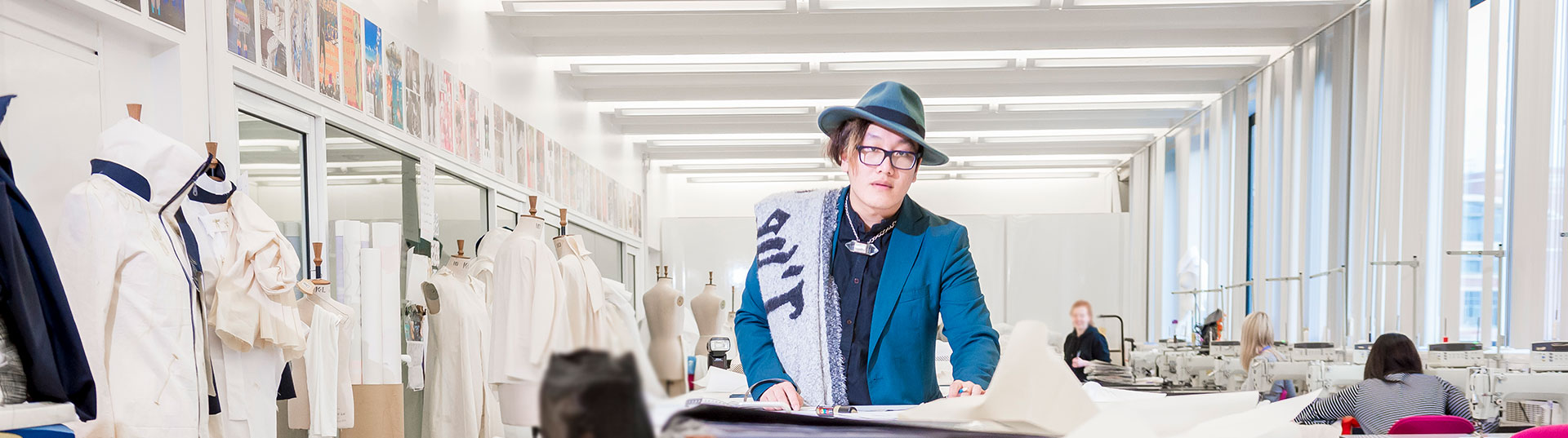 Fashion student wearing a blue hat colourful jacket. 