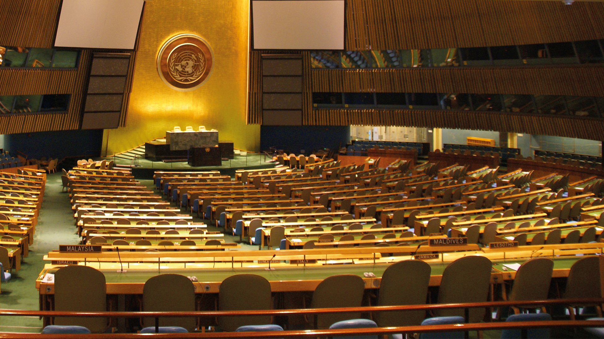 Empty indoor amphitheatre with benches on green carpet