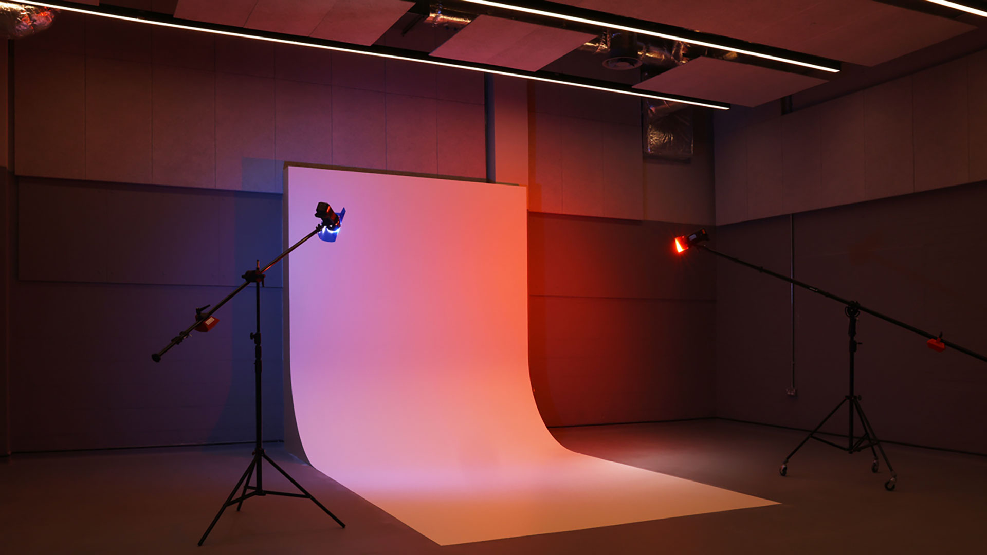 Photography studio with a white background, coloured lights and equipment around