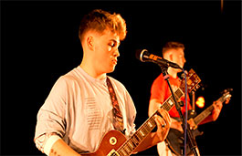 Two students playing guitar and singing