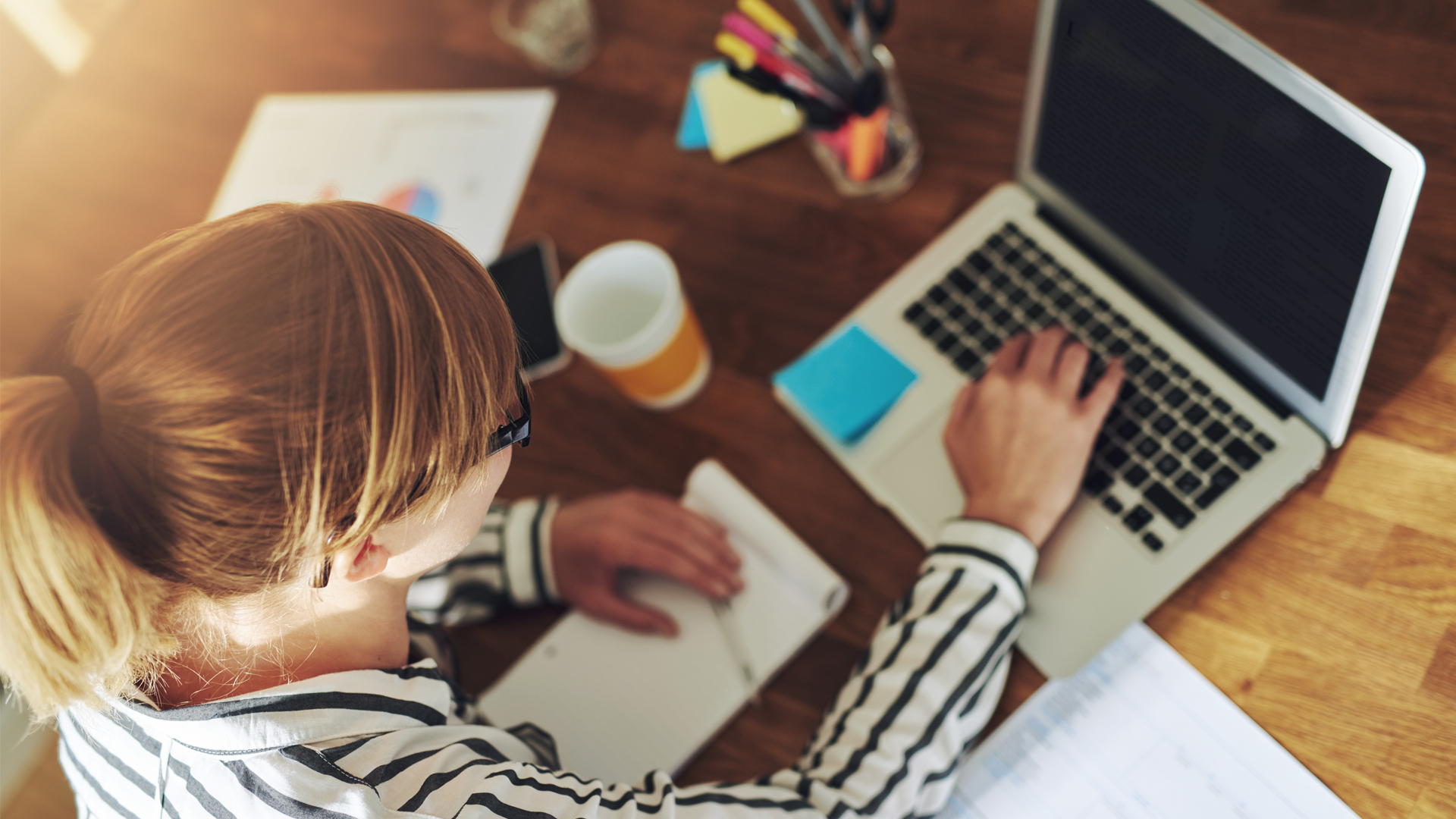 A woman working at her laptop with a cup of coffee