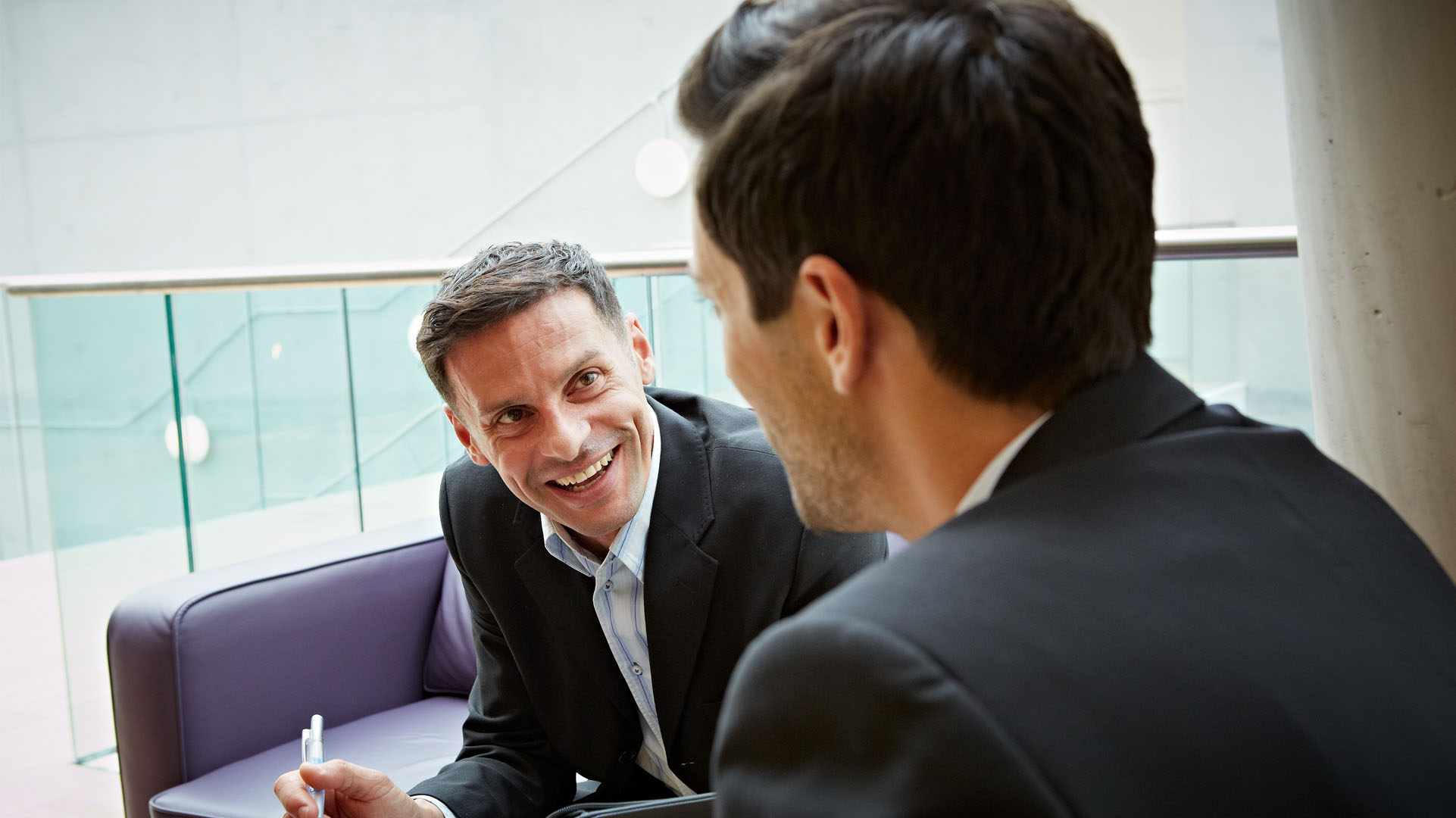 Two men wearing suits having a serious conversation.