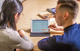 Two students looking at a small screen between them