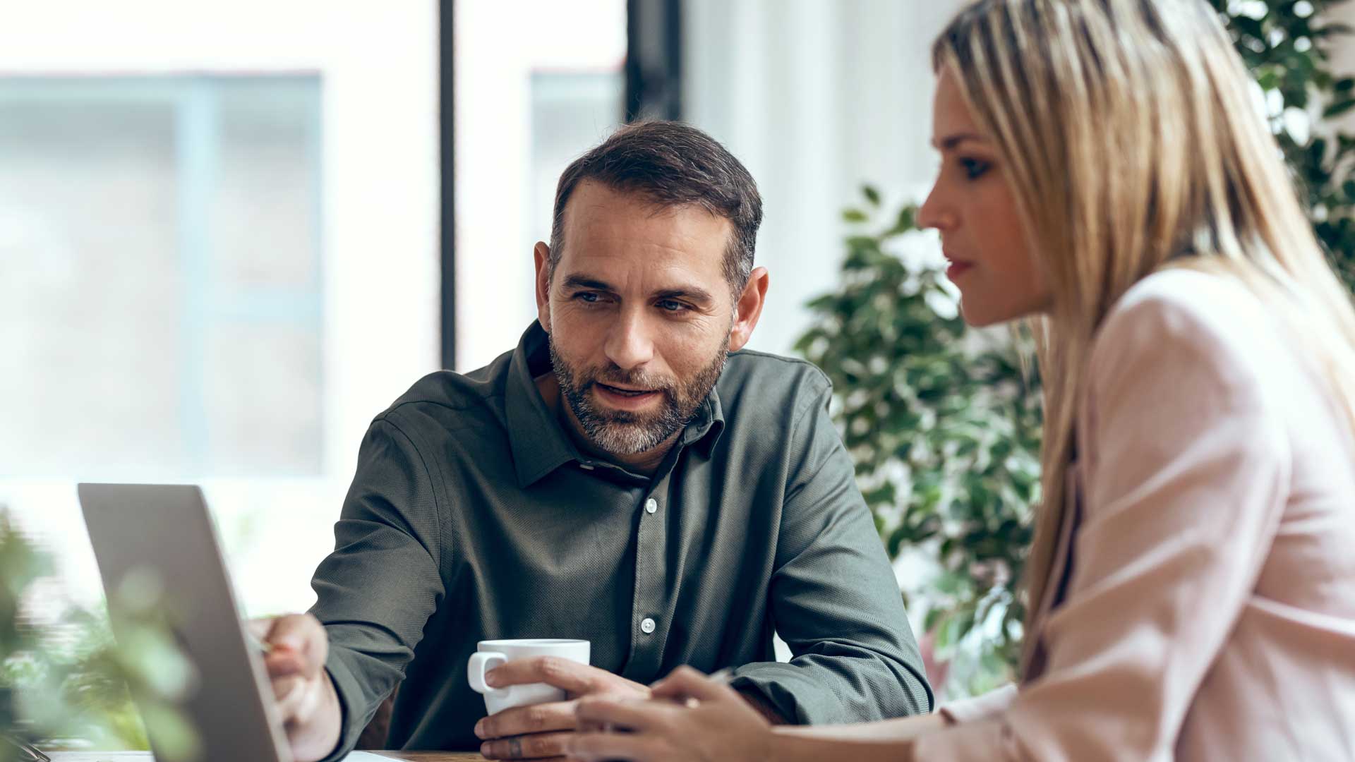 Two people look at a laptop screen together
