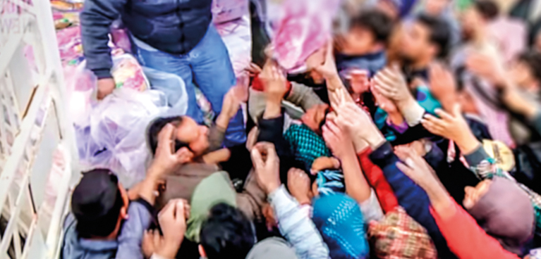 Crowd of people reaching out for supplies