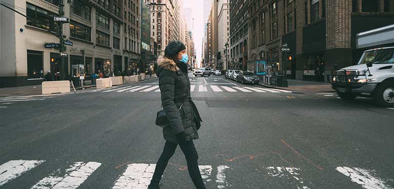 Woman wearing a mask crossing the road