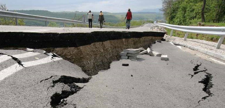 Large hole near a bridge with people crossing