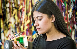 Female student working on a small model car