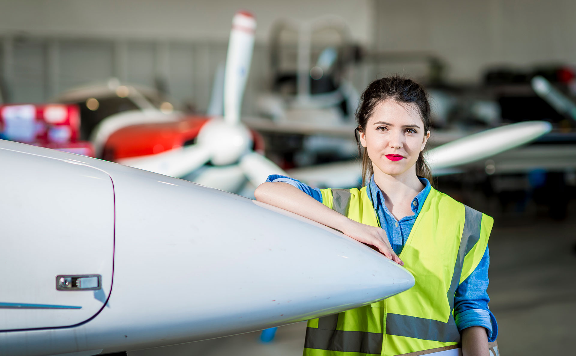 Female leaning against a plane