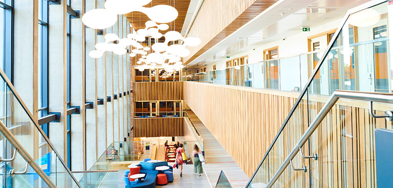 Inside of a big building with hanging lights and big staircase