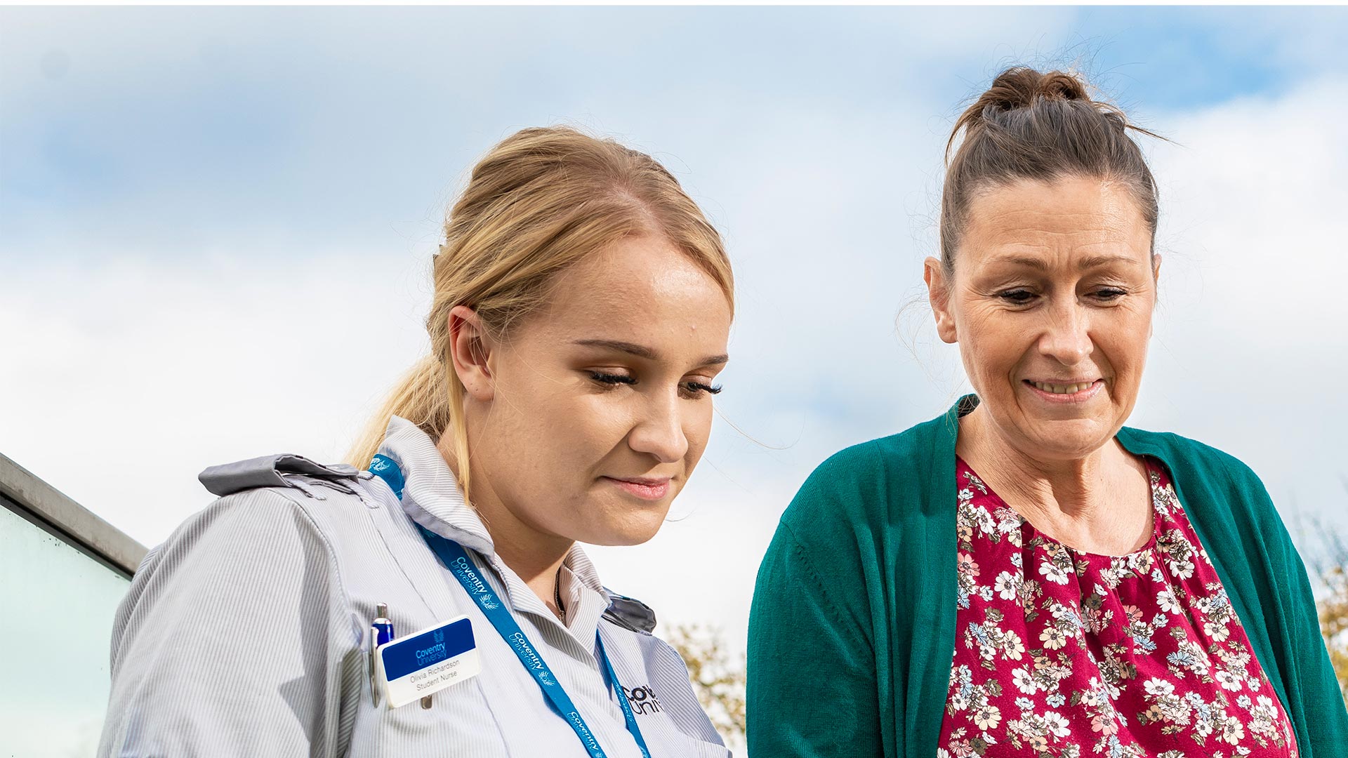 A nurse and a woman looking down