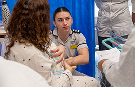 Female student sat talking to a new mother holding a baby