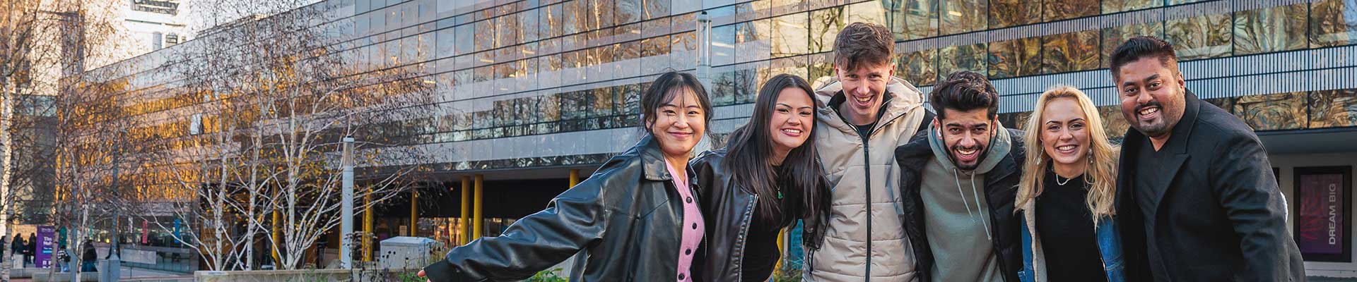 Group of smiling students outside the StudentHub