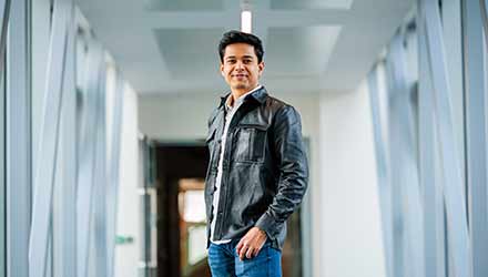 Postgraduate male student standing in a corridor