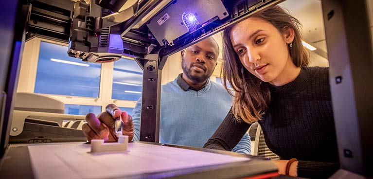 Students watching a 3D printer