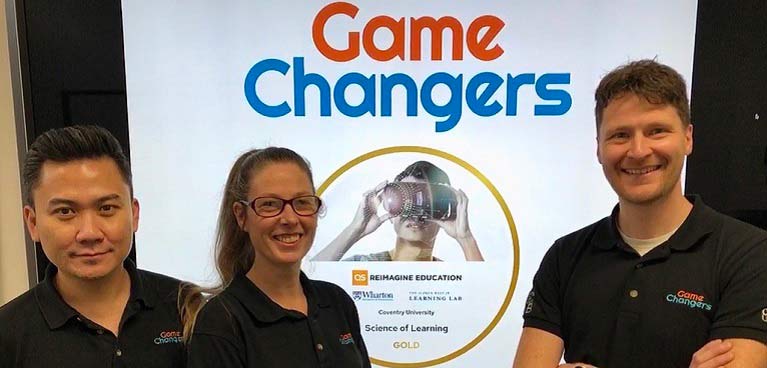 Three members of University staff in front of Gamechangers logo.