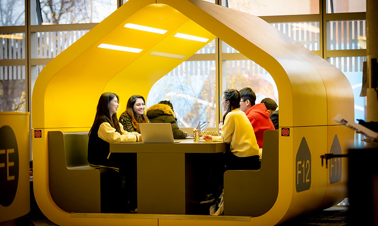 Group of students sat at a table in a booth