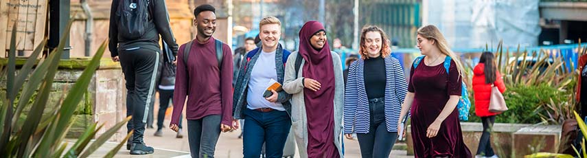 Group of students walking through the city smiling