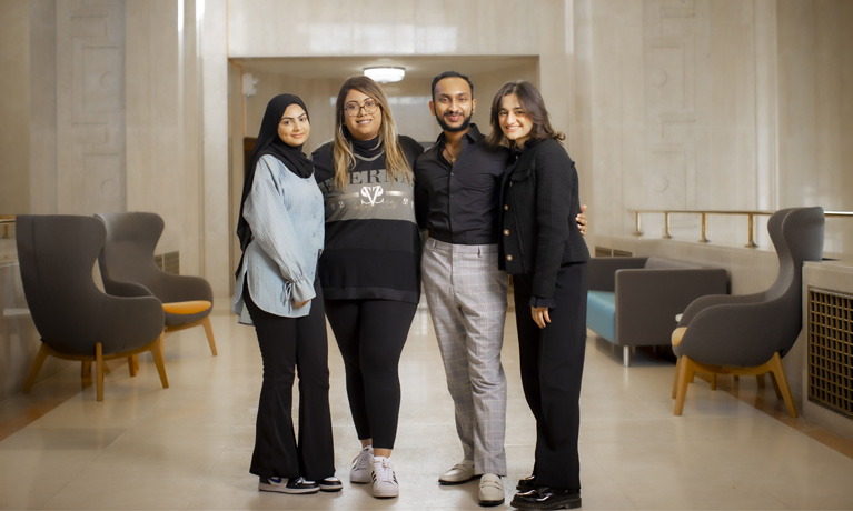 Four students stood together smiling